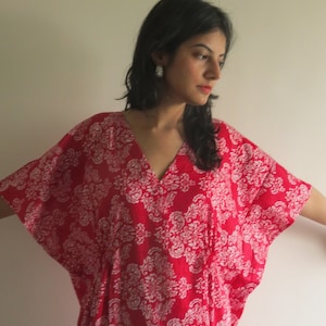 Op de afbeelding: Een rood-witte gepatroneerde kaftan met een V-hals. De kaftan is gemaakt van een lichtgewicht stof en heeft een ontspannen pasvorm.