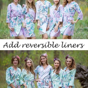 May include: Six women wearing floral print robes in shades of lavender, white, and mint green. The robes have a wrap-around design with matching belts. The image includes the text "Add reversible liners".