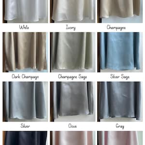 May include: A satin colour chart showing fabric swatches in a range of colours. The chart includes shades such as white, ivory, champagne, dark champagne, champagne sage, silver sage, silver, dove, grey, black, blush, and baby pink.