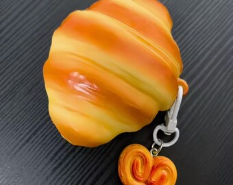 Funda para AirPods con diseño de pan tostado y galletas, ideal como regalo para amantes de la comida.