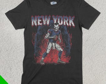 Könnte beinhalten: Schwarzes T-Shirt mit einem Grafikdruck eines Footballspielers in einem blau-roten Trikot mit dem Schriftzug "NEW YORK" darüber. Der Spieler ist von einer dunklen, schattenhaften Gestalt umgeben.