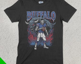 May include: Black t-shirt featuring a graphic of a football player holding a football and a buffalo with the word "BUFFALO" above them.