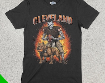 May include: Black t-shirt featuring a graphic of a skeleton football player holding a football and a brown pit bull dog. The text "CLEVELAND" is printed in white above the graphic.