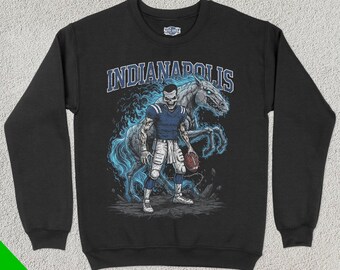 Könnte beinhalten: Schwarzer Pullover mit einem Grafikdruck eines Footballspielers in blau-weißem Trikot, hinter dem ein geisterhaftes Pferd steht. Der Text "INDIANAPOLIS" ist in Weiß über dem Grafikdruck gedruckt.