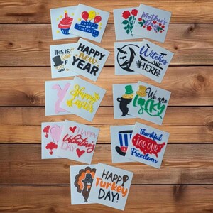 May include: A collection of 12 colourful vinyl stickers with various holiday themes. The stickers feature designs such as a cupcake, a turkey, a witch's hat, a pot of gold, and a heart with the text "Happy Valentine's Day".