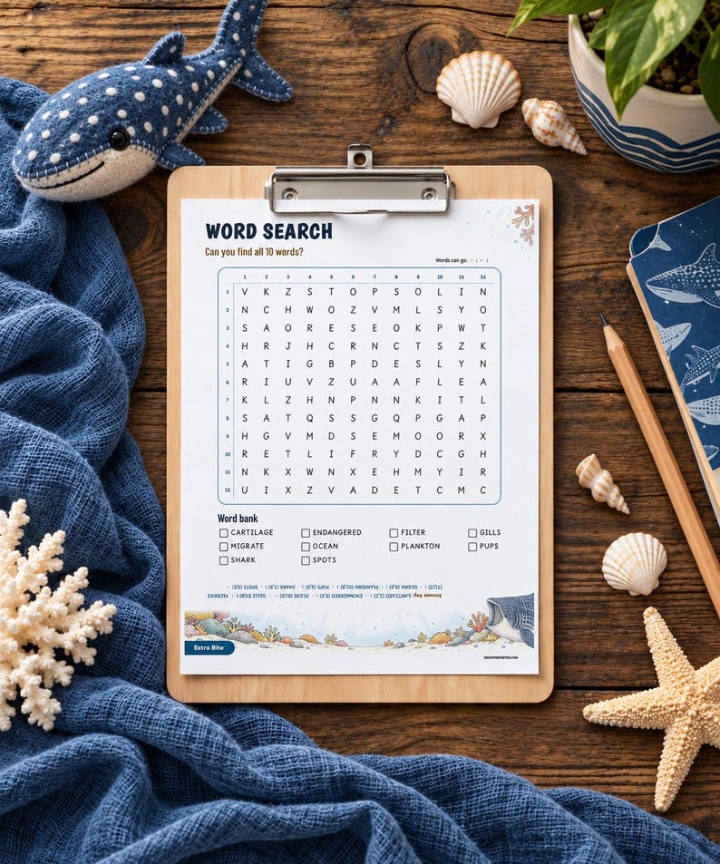 May include: A word search puzzle sheet on a wooden clipboard featuring a shark theme. The grid contains letters and a word bank with terms like Cartilage, Endangered, Filter, Gills, Migrate, Ocean, Plankton, Pups, Shark, and Spots. The bottom border displays colorful coral reef illustrations.