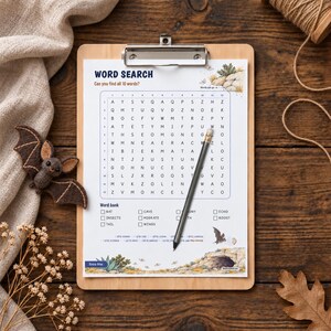 May include: A word search puzzle sheet on a wooden clipboard with a pencil resting on the grid. The sheet features the title WORD SEARCH, a 12x12 letter grid, a word bank with ten terms, and illustrations of bats and a cave entrance.