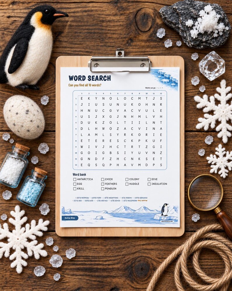 May include: A word search puzzle sheet on a wooden clipboard featuring a grid of letters, a word bank with terms like Antarctica and penguin, and illustrations of icebergs. The sheet is surrounded by a felt penguin, an egg, snowflakes, and a magnifying glass.