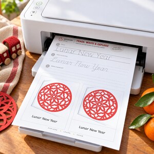 May include: A white printer outputting a worksheet titled Trace, Write & Explore Lunar New Year. The page features dotted lines for handwriting practice and two red circular paper-cut floral designs with the text Lunar New Year below each.