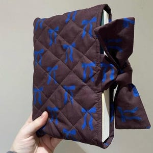 May include: A set of three ceramic mugs with a speckled, matte finish. The mugs are in shades of cream, light gray, and dark gray. Each mug has a simple, minimalist design and a rounded handle. Perfect for coffee or tea.