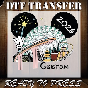 May include: DTF transfer design featuring a colorful illustration with a Mickey Mouse hand holding a wand, a geometric sphere, and various buildings. The design includes the text "2026" and "Custom". The words "READY TO PRESS" are also included.