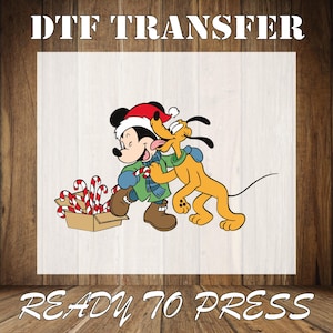 May include: Mickey Mouse and Pluto wearing Santa hats and holding candy canes. Mickey is wearing a green and white sweater and Pluto is wearing a red collar. They are standing in front of a box of candy canes. DTF TRANSFER READY TO PRESS