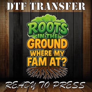 May include: DTF transfer design with the text "ROOTS IN THE GROUND WHERE MY FAM AT?" in green and orange, with a tree graphic. The words "READY TO PRESS" are at the bottom. The background is a dark wood grain.