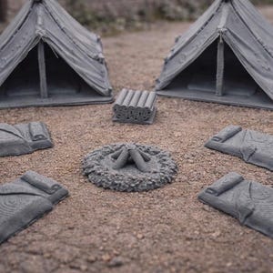May include: Miniature gray camping set with two tents, four sleeping bags, a campfire, and a stack of logs. The set is designed for tabletop gaming or model displays. The tents have an open front.