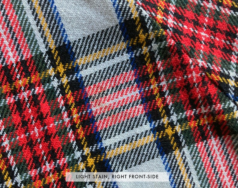 Puede incluir: Primer plano de una tela tejida con un patr&oacute;n de cuadros. El dise&ntilde;o presenta una mezcla de l&iacute;neas rojas, verdes, negras, amarillas, blancas y azules. La tela tiene un aspecto texturizado. El texto "LIGHT STAIN, RIGHT FRONT-SIDE" es visible.