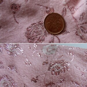 May include: Close-up of pink fabric with a floral pattern. The fabric has a textured appearance with silver metallic accents. A Canadian one-cent coin is placed on the fabric for scale.