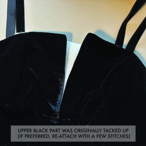 May include: A black velvet bodice featuring thin shoulder straps and a deep center front slit revealing a white fabric panel underneath. The garment includes text stating: UPPER BLACK PART WAS ORIGINALLY TACKED UP (IF PREFERRED, RE-ATTACH WITH A FEW STITCHES).