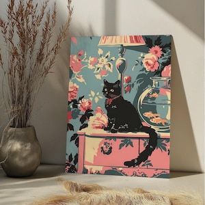 May include: A black cat with a red ribbon sits on a pink and white dresser in front of a blue and pink floral wallpaper. A glass fishbowl with gold fish is on the dresser next to the cat.