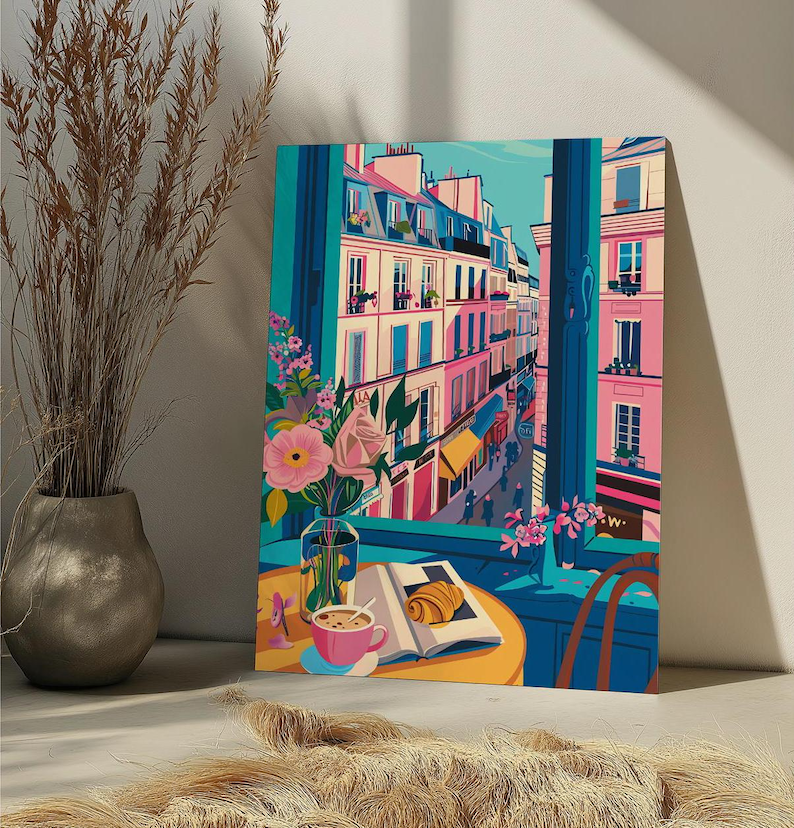 Peut inclure: Une peinture color&eacute;e d'une sc&egrave;ne de rue parisienne vue d'une fen&ecirc;tre. La peinture repr&eacute;sente un caf&eacute; avec une marquise jaune, un croissant sur un livre et une tasse de caf&eacute; sur une table. La rue est bord&eacute;e de b&acirc;timents roses et jaunes.
