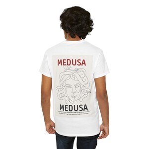 Könnte beinhalten: Weißes T-Shirt mit einem Grafikdruck von Medusa, einer mythischen griechischen Figur mit Schlangenhaaren. Die Grafik ist in Schwarzweiß mit dem Wort "MEDUSA" in Rot oben und unten im Design.