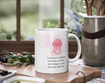 May include: White ceramic mug with a pink jellyfish illustration and the text "I wanna be a jellyfish no heart, no brain. no feelings, no pain just blub blub blub."