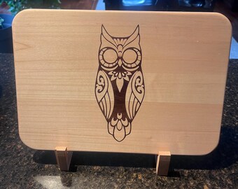 Hard maple cutting board with a walnut inlay of an owl.