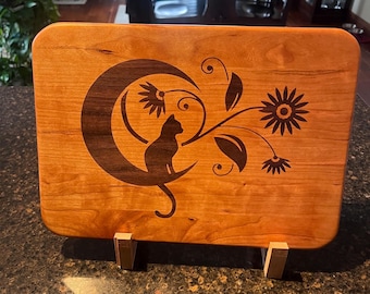 Cherry cutting board with a walnut inlay of a cat and moon.