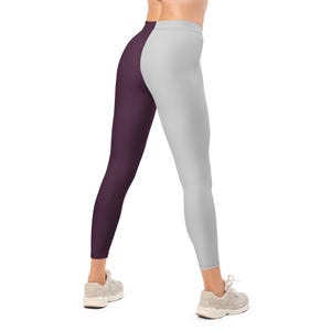 May include: Leggings with a split design, featuring a deep purple panel on the left and a light gray panel on the right. The leggings are form-fitting and reach the ankles. The model is wearing beige sneakers.