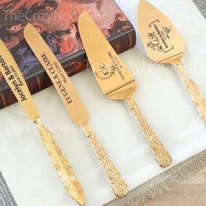 Può includere: Un set di utensili dorati per servire la torta nuziale. Il set include un coltello e una paletta per torta, ciascuno inciso con nomi e una data. Il coltello ha un design a piuma, mentre la paletta ha un motivo floreale.