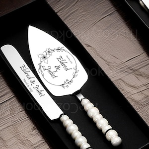 Puede incluir: Un juego de cuchillo para cortar pastel de plata con mangos de perlas. El cuchillo tiene el texto "Eldred & Juliet March 15, 2025" grabado en él. El servidor tiene el texto "Eldred & Juliet Married 2025" grabado en él.