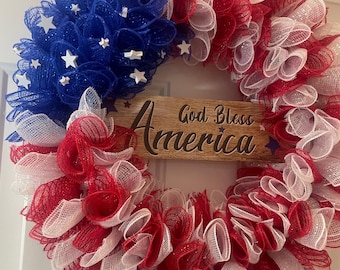 Una corona de Meah con la bandera del 4 de julio y el letrero "Dios bendiga a América" (20 pulgadas) de vid.