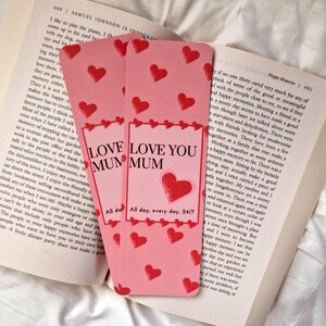 May include: Two pink bookmarks with red hearts and the text "LOVE YOU MUM". The bookmarks also include the phrase "All day, every day, 24/7".