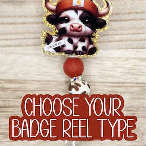 May include: A badge reel featuring a cartoon cow wearing a Carhartt beanie and a gold glitter border. The reel has a red and white beaded accent and the text "CHOOSE YOUR BADGE REEL TYPE".