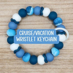 May include: A blue, white, and marbled bead wristlet keychain. The keychain has a variety of blue beads, including dark blue, light blue, and marbled blue. The text "CRUISE/VACATION WRISTLET KEYCHAIN" is displayed on a blue background.