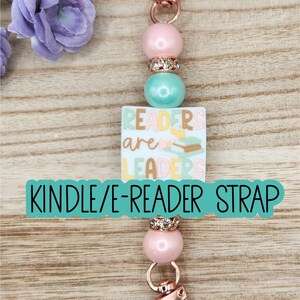 May include: A beaded strap featuring a rose gold lobster clasp at each end, pink and mint green beads, and rhinestone spacers. A square white charm in the center displays the text READERS are LEADERS with a small illustration of stacked books.