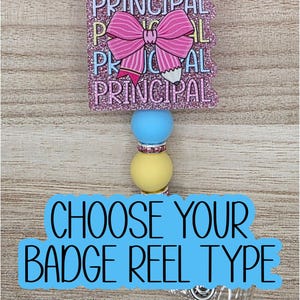 May include: A badge reel featuring a square pink glitter topper with the word PRINCIPAL repeated in white text and a pink striped bow graphic. Below the topper are blue and yellow silicone beads with silver rhinestone spacers.