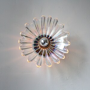 May include: A clear glass ceiling light fixture shaped like a flower with iridescent accents.
