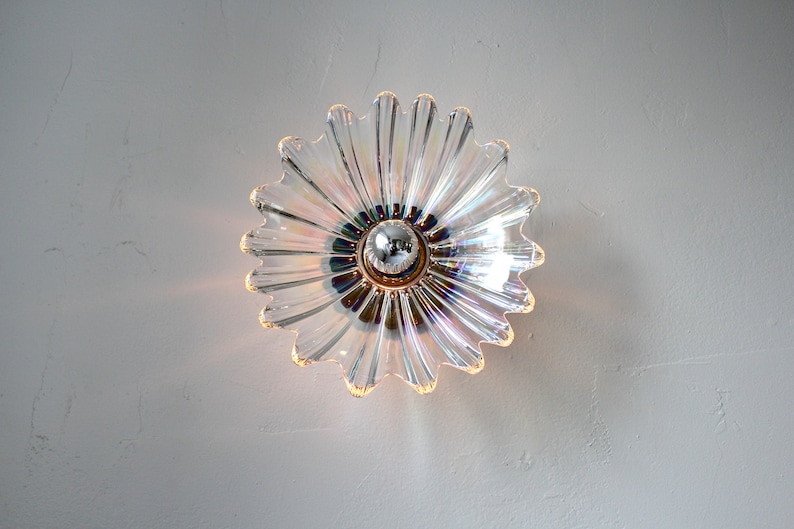May include: A clear glass ceiling light fixture shaped like a flower with iridescent accents.