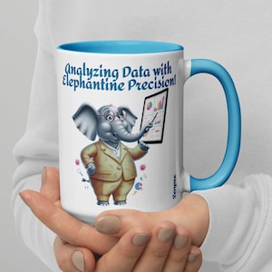 Peut inclure: Une tasse en céramique blanche avec un bord et une anse bleus. La tasse représente un éléphant de dessin animé portant des lunettes et un costume, tenant une tablette avec des graphiques et des diagrammes. Le texte sur la tasse est "Analyser les données avec une précision d'éléphant !"