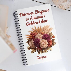 Może przedstawiać: Biały notes w oprawie spiralnej z tekstem "Discover Elegance in Autumn's Golden Glow" i ilustracją kwiatową z jesiennymi kwiatami i kłosami pszenicy. Na dole notesu znajduje się tekst "Zenpex".