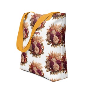 May include: A white tote bag with a floral pattern featuring a bouquet of burgundy, pink, and beige flowers with brown leaves and beige grasses. The bag has yellow straps and the word "enpex" printed on the front.