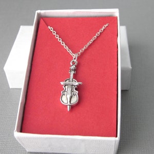 Small sterling silver cello charm and chain necklace. Cello flat on back with .925 stamp.  Choose length 18, 17, or 16 inches. Charm measures 23mm x 10mm at bow, x 9mm thick. Comes with a gift box wrapped in music themed gift paper.