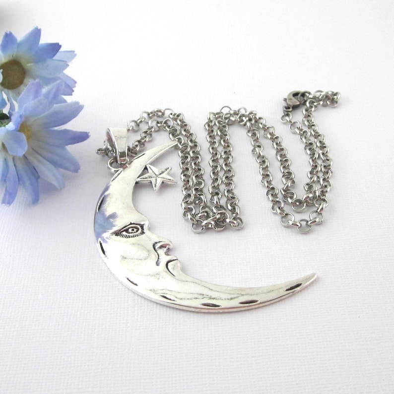 Make a statement with this very large silver tone crescent moon and star pendant, with man in the moon face. Includes a sturdy silver plated rolo chain available in three lengths 28, 27, or 26 inches.  The moon measures 3 1/4" x 2". Includes organza gift pouch.  Unisex for either women or men.