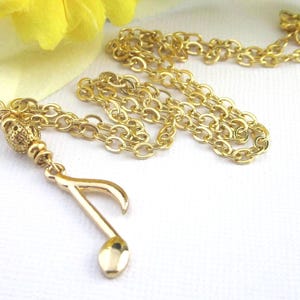 Small gold plated 8th note charm dangles from a gold filigree bead. The full length of the pendant is 1 3/4 inches long.  Comes with a shiny gold plated flat cable chain. Choose 19, 18, or 17 inches long.