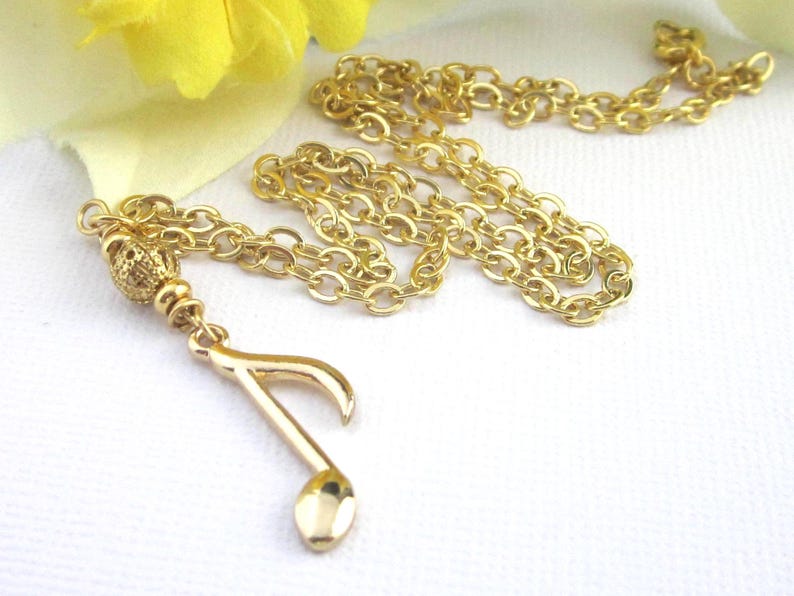 Small gold plated 8th note charm dangles from a gold filigree bead. The full length of the pendant is 1 3/4 inches long.  Comes with a shiny gold plated flat cable chain. Choose 19, 18, or 17 inches long.