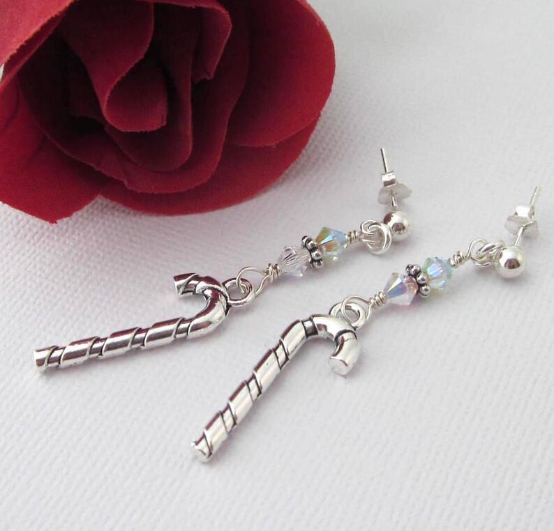 Silver tone candy cane earrings with clear AB Swarovski crystal bicones and  TierraCast Heishi daisy spacers. Sterling silver post and clutch. Length 2 1/8 inches long, candy canes alone are 27mm x 9 mm. Organza gift pouch included.