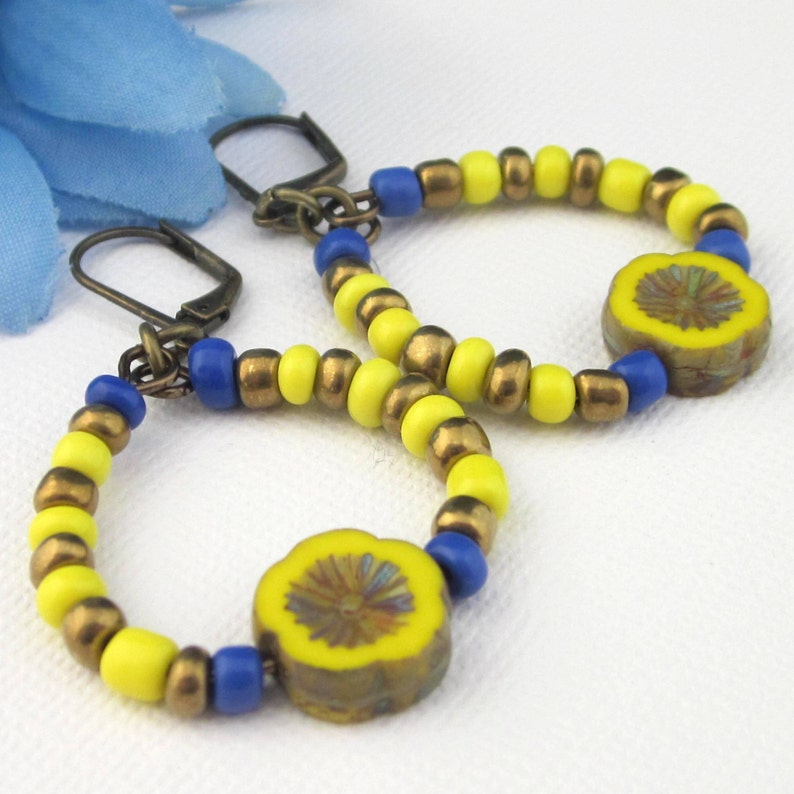 Hoop flower and seed bead earrings in Ukraine's colors of bright yellow and blue.  I also added some bronze.  Ear wires are antiqued brass lever backs.   Hoops 33 mm x 30 mm.  Length of earrings 2 1/8  inches. Czech flower bead 12 mm