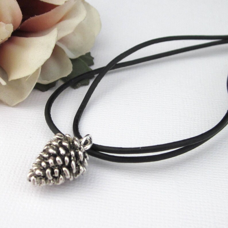Small size antiqued silver pinecone charm necklace with double 2 millimeter black leather cords. Pinecone is dimensional with scales.  Choose from two lengths, 16 to 17 inches, or 18 to 19 inches.