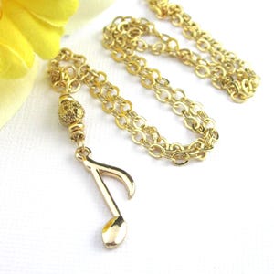 Small gold plated 8th note charm dangles from a gold filigree bead. The full length of the pendant is 1 3/4 inches long.  Comes with a shiny gold plated flat cable chain. Choose 19, 18, or 17 inches long.