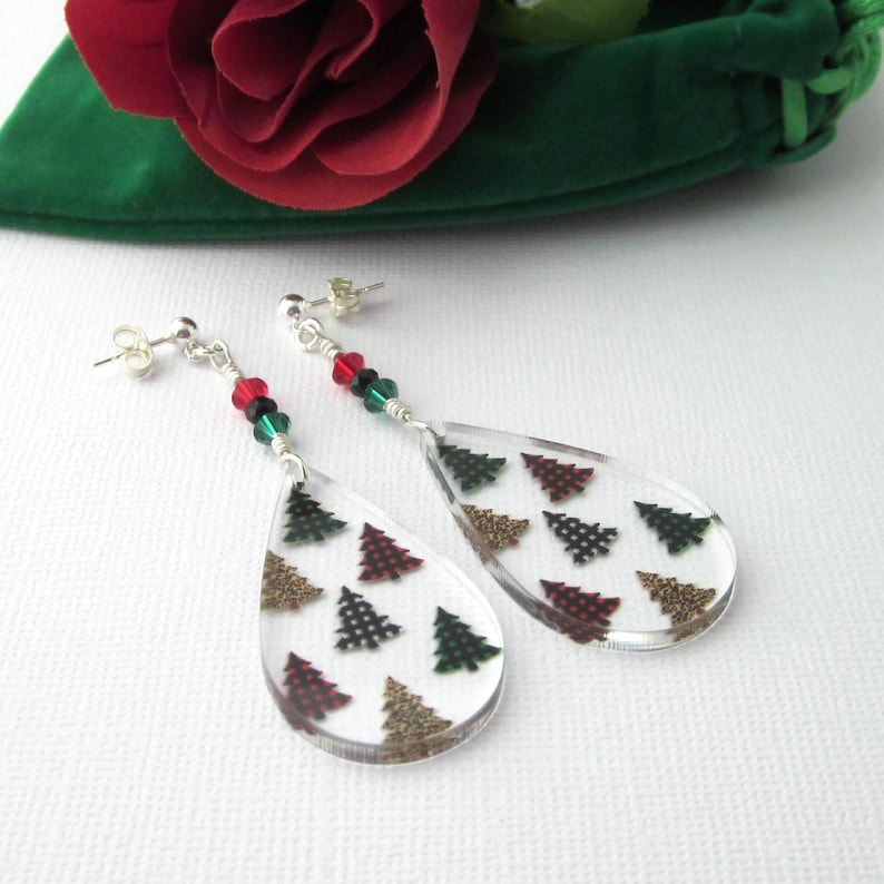 Acrylic teardrop shape drops have Christmas trees with buffalo plaids and leopard prints. Sparkling red, green and black crystals and sterling silver posts and clutches. Green velour gift pouch included.